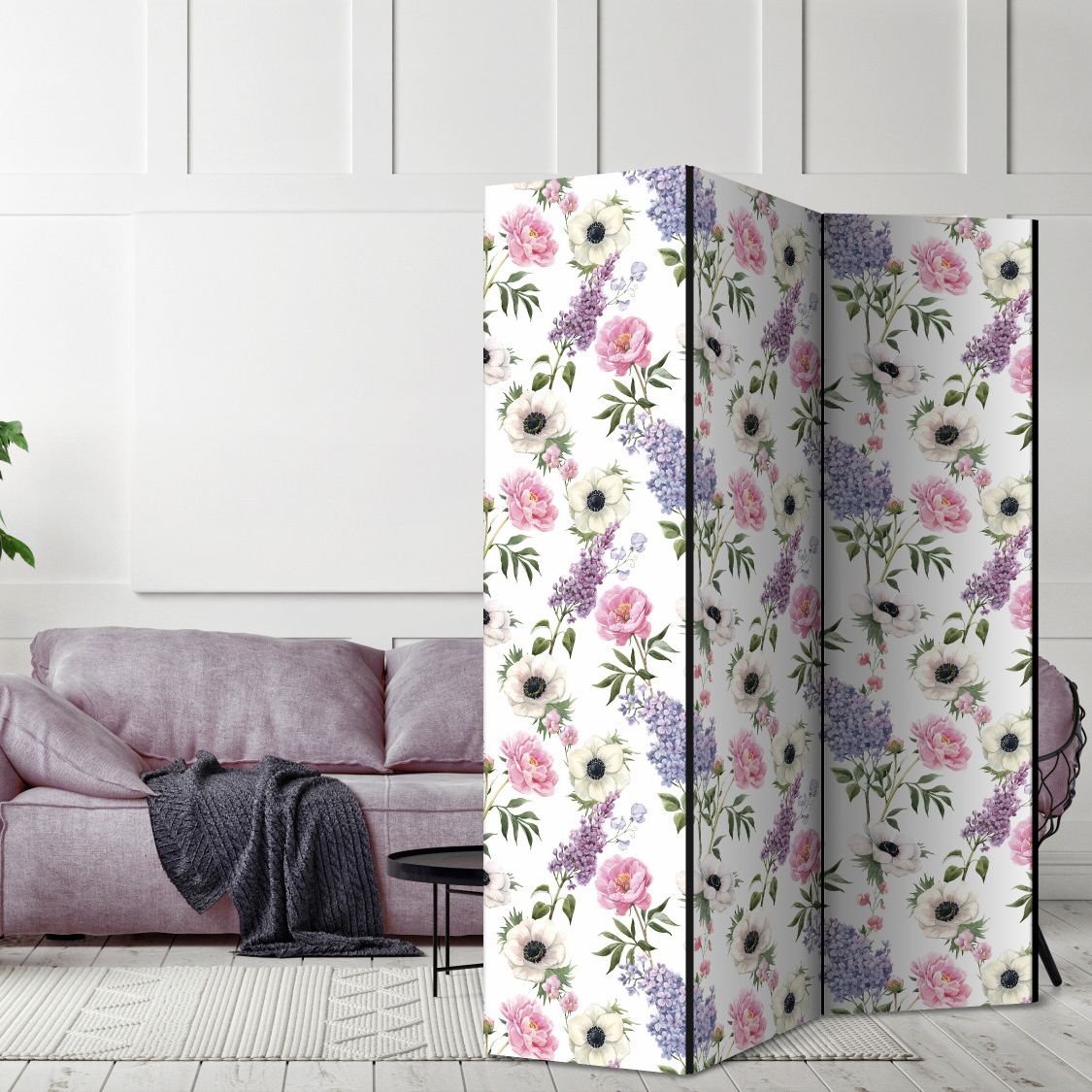 a beautiful modern living room with 3 panels floral patterned room divider screen covering half of a sofa that is purple and look stunning with the shades of purple and pink that this folding canvas screen has