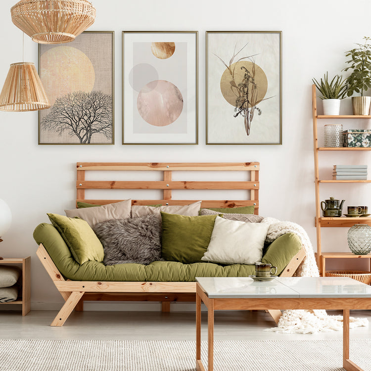 A living room with a wooden couch, a coffee table, and three autumn themed artwork framed posters on the wall