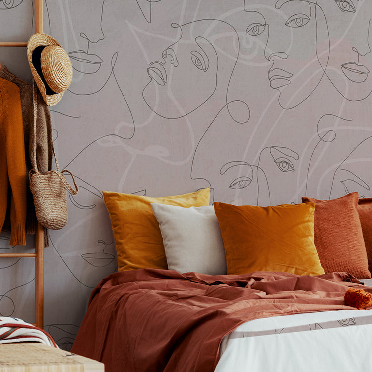 a beautiful orange bedroom with an awesome wallpaper that have dreamy faces designed in the style of line art over a pink background, this wall mural changed the look of the bedroom completely 