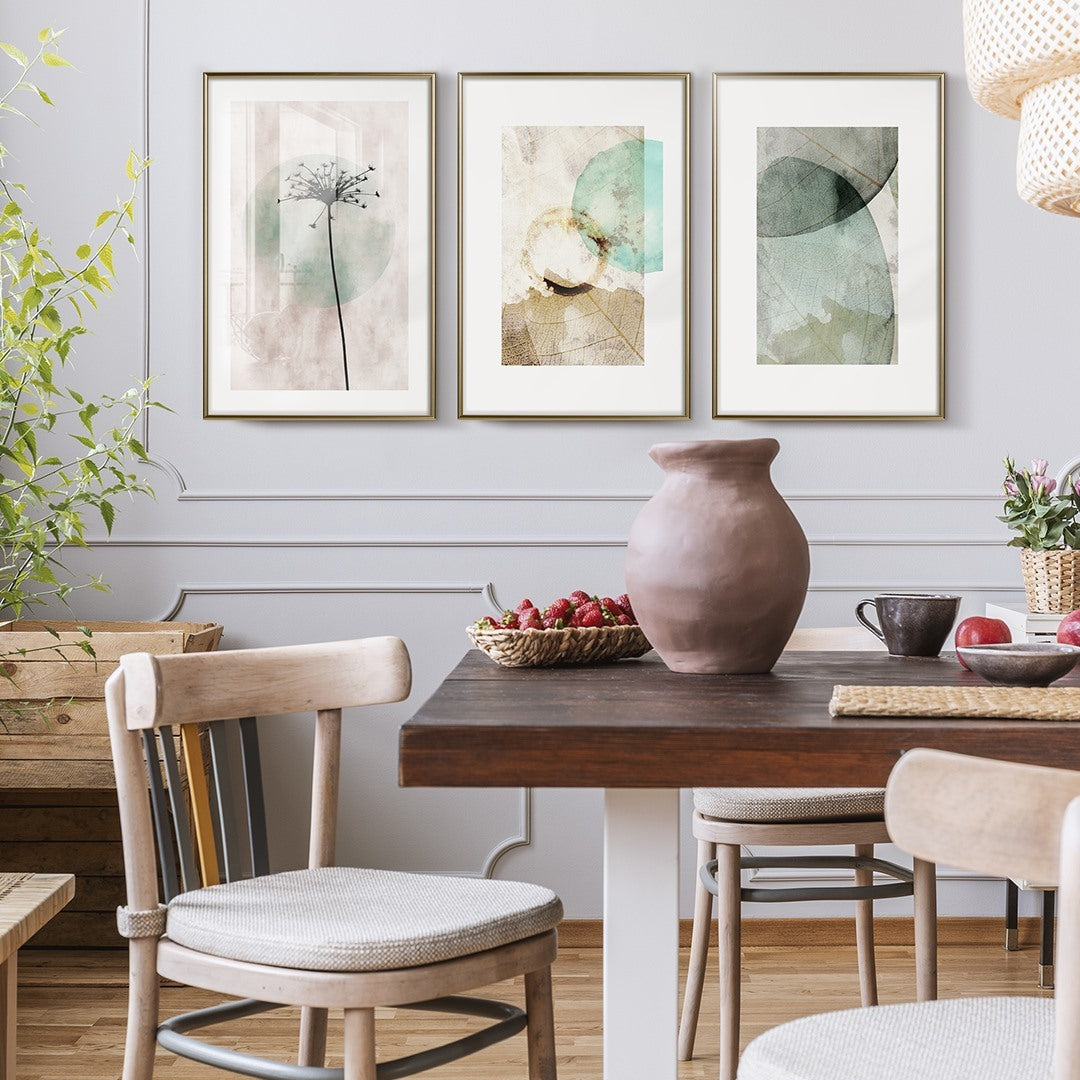 A cozy dining area with a wooden table, chairs, and two botanical framed posters artwork on the wall.