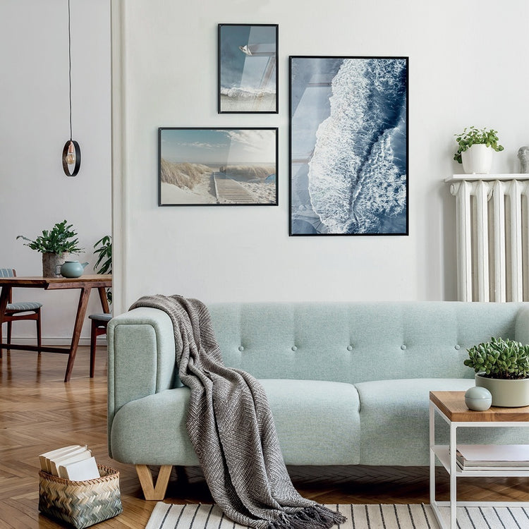 sea inspired framed posters mounted on a living room with a blue couch