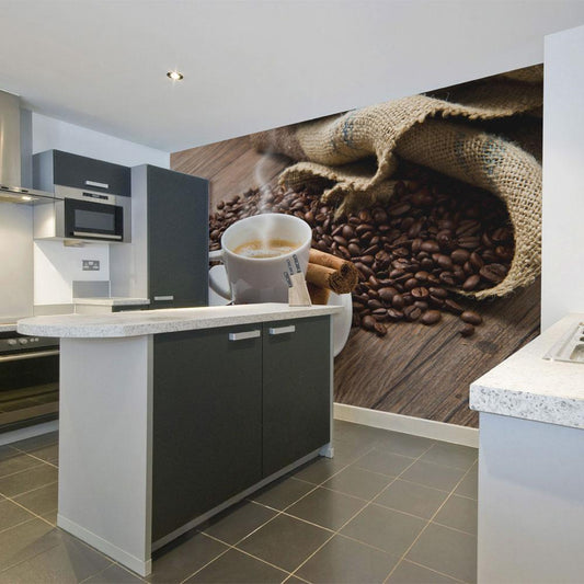 a wallpaper in a kitchen, the wallpaper have a design of black coffee beans and a cup next to cinnamon roll