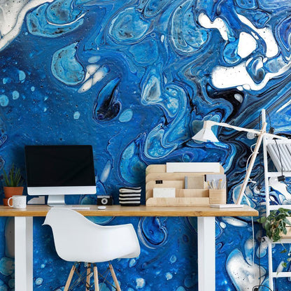 a blue marbled wallpaper mural in a home office setting next to a desk and a mac plus a lamp on the desk